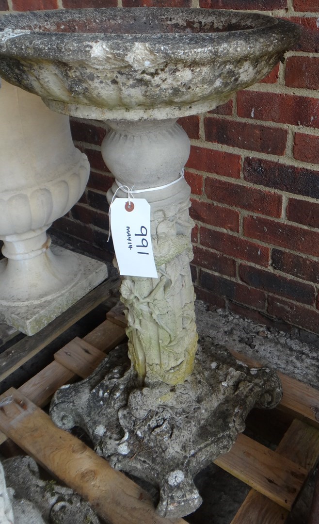 Appraisal: A reconstituted stone birdbath on fluted column relief moulded with