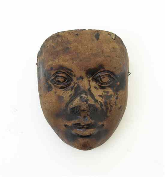 Appraisal: A Stoneware Mask having remnants of a deep brown glaze