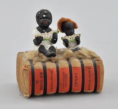 Appraisal: Black Americana German Bisque Figurines on Cotton Bale Bisque figurines