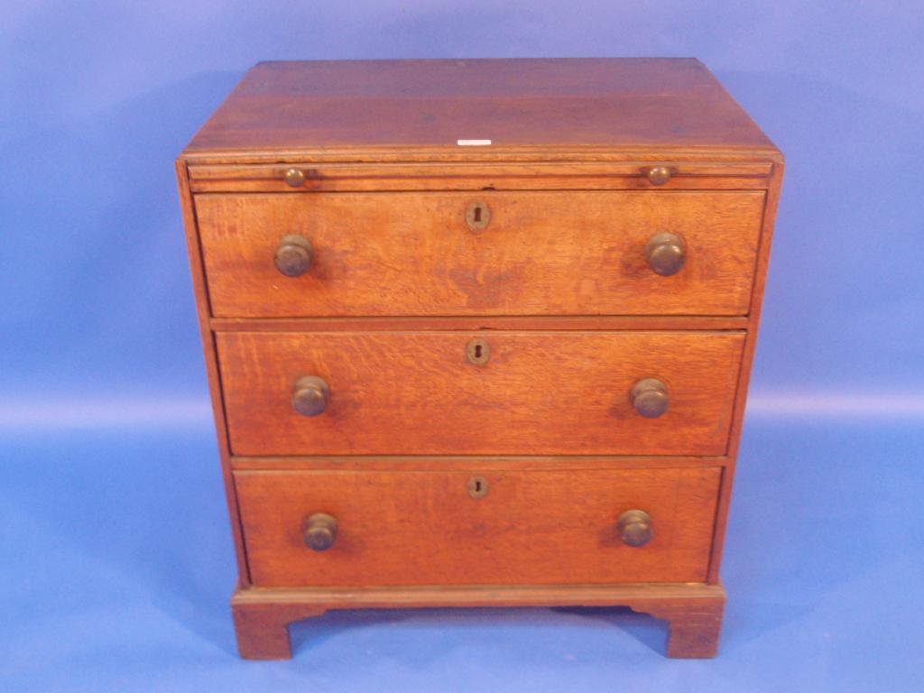 Appraisal: A Georgian oak bachelors chest having moulded caddy top brushing