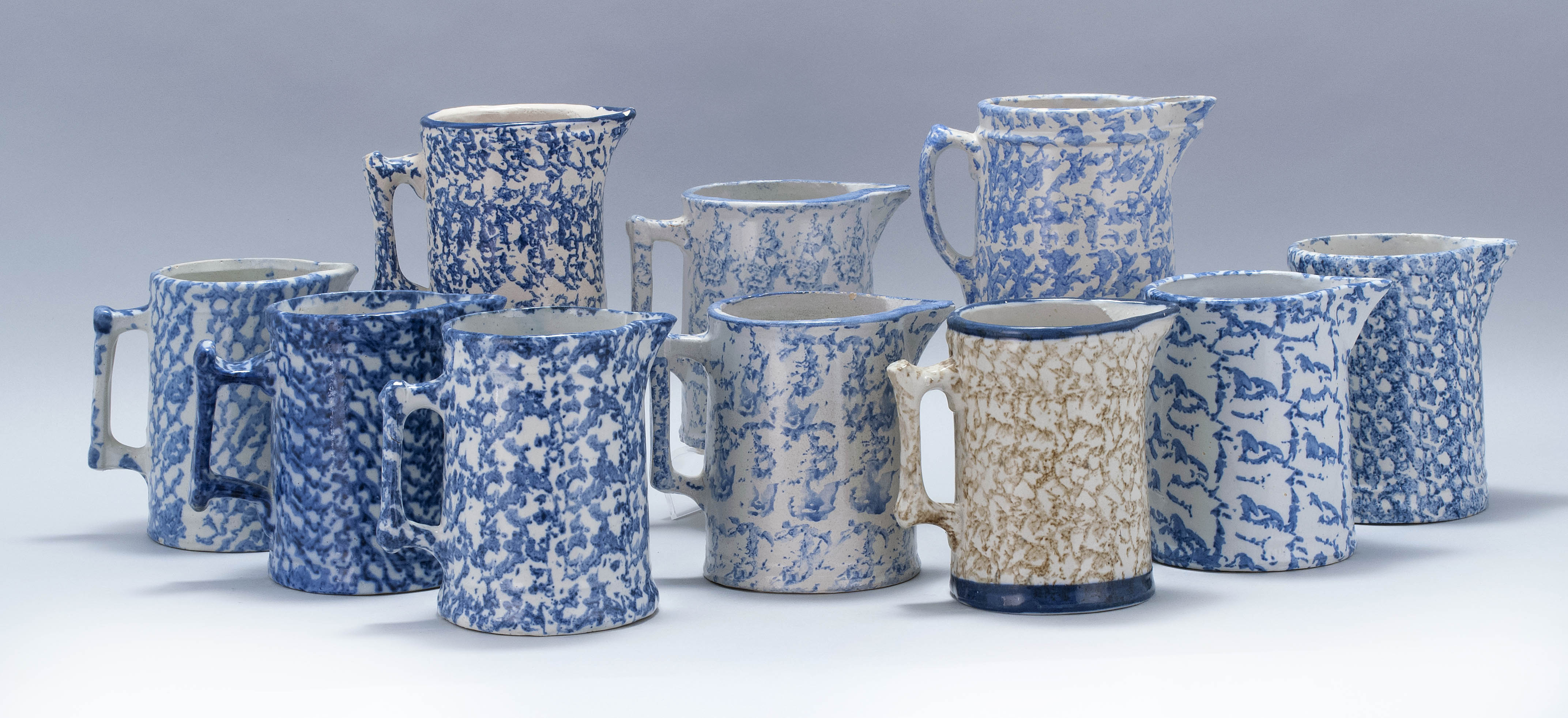 Appraisal: TEN SPONGEWARE POTTERY HANDLED PITCHERS Most th CenturyNine in blue