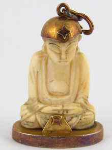 Appraisal: A hand carved ivory Buddha mounted in yellow metal tests