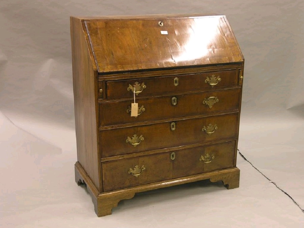 Appraisal: A George I walnut bureau cross-banded fall-front enclosing fitted interior