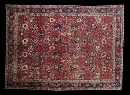 Appraisal: PERSIAN CARPET The wine red field with lotus and vine