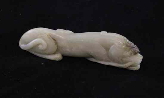 Appraisal: A Chinese pale celadon jade carving of a lion dog