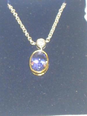 Appraisal: A TANZANITE AND DIAMOND PENDANT comprising oval cut tanzanite collet