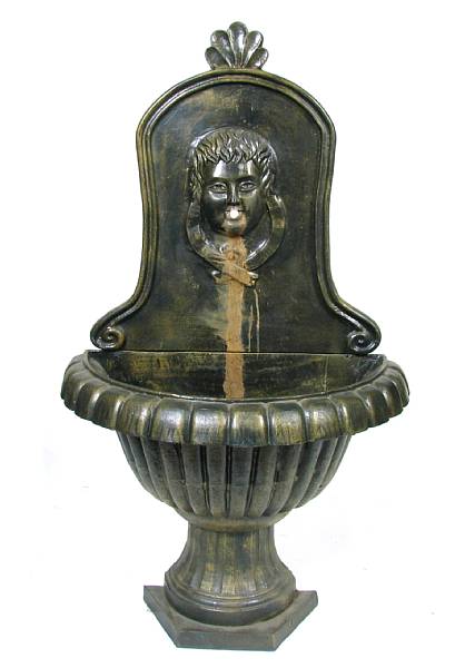 Appraisal: A cast iron wall fountain with the face of a