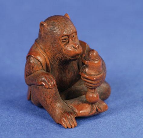 Appraisal: A JAPANESE HARDWOOD NETSUKE carved as a grotesque monster rolling