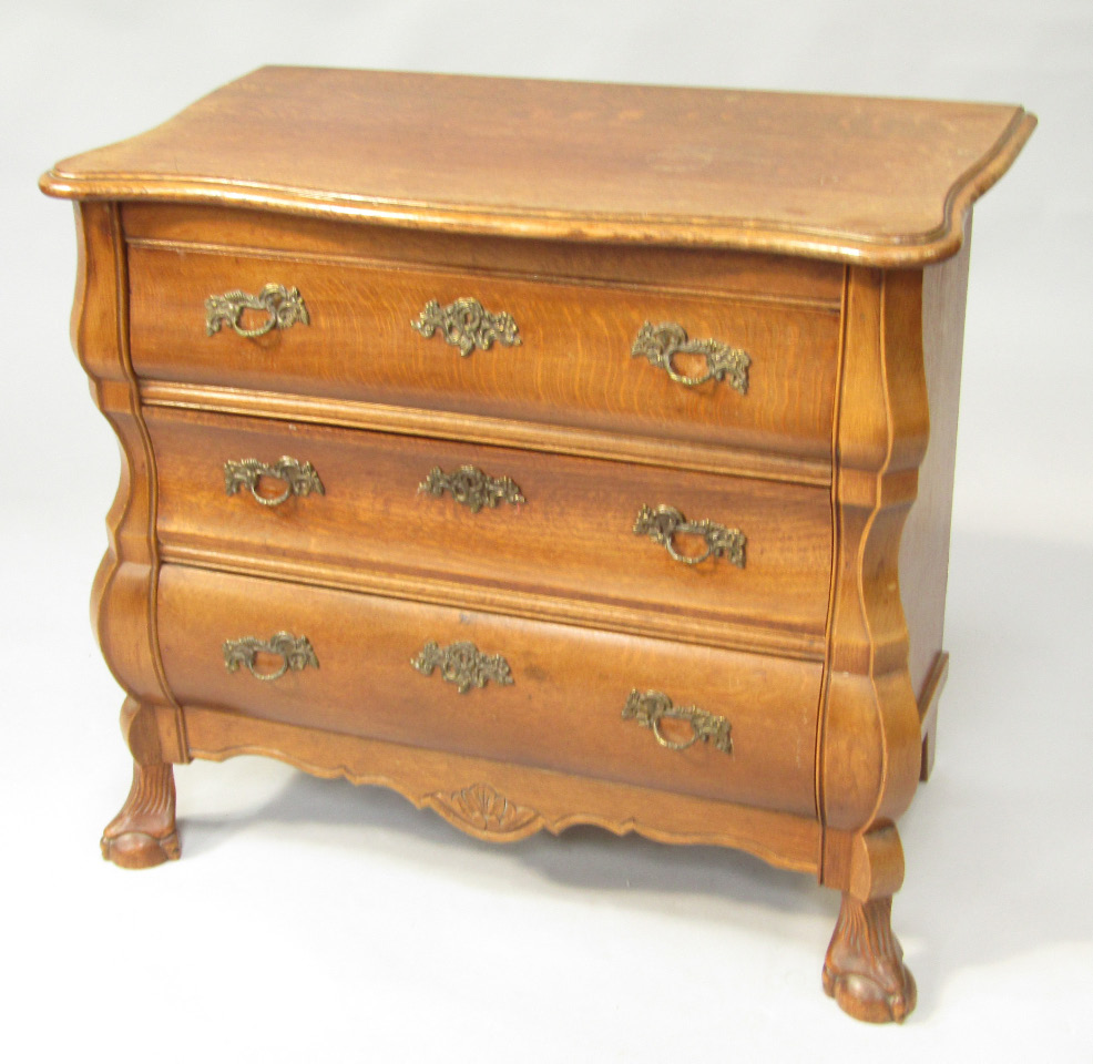 Appraisal: A Continental bombe oak chest of three drawers serpentine top