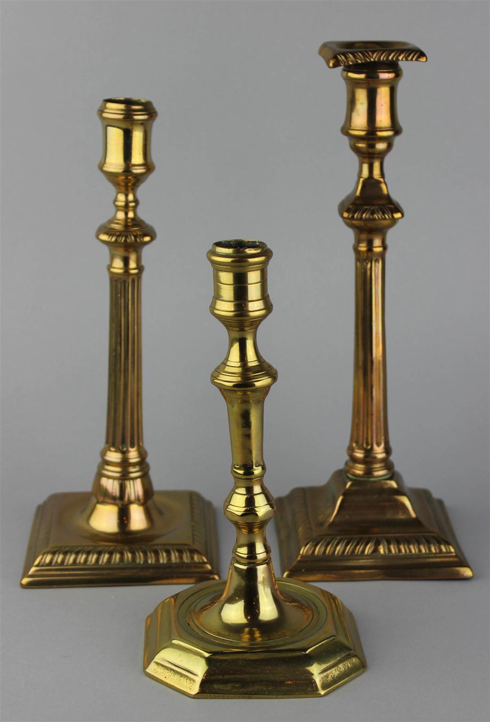 Appraisal: TWO BELL METAL COLUMNAR CANDLESTICKS AND ONE BRASS WITH PANELED