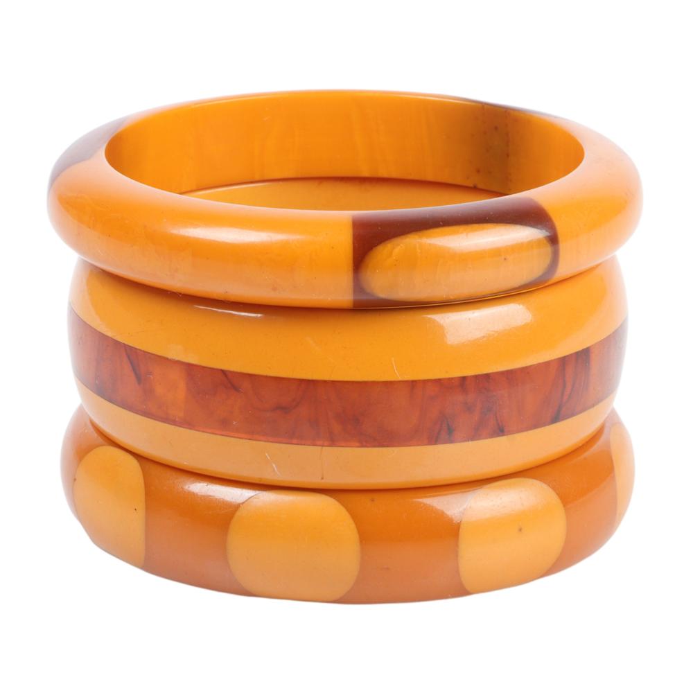 Appraisal: THREE BAKELITE LAMINATED BANGLE BRACELETS WITH GEOMETRIC DESIGNS INNER DIAM