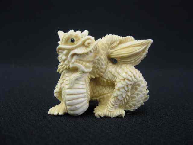 Appraisal: Carved Ivory Netsuke of a Dragon onyx eyes signed ''