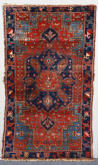 Appraisal: A KURDISH RUST GROUND RUG with a central blue ground