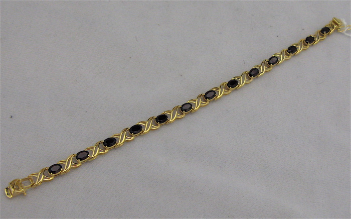 Appraisal: GARNET AND TEN KARAT GOLD BRACELET set with oval-cut red