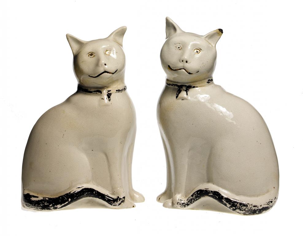 Appraisal: A PAIR OF STAFFORDSHIRE EARTHENWARE MODELS OF CATS with black