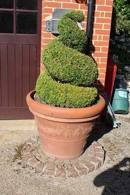 Appraisal: A PAIR OF LARGE TERRACOTTA GARDEN POTS with fruit swag