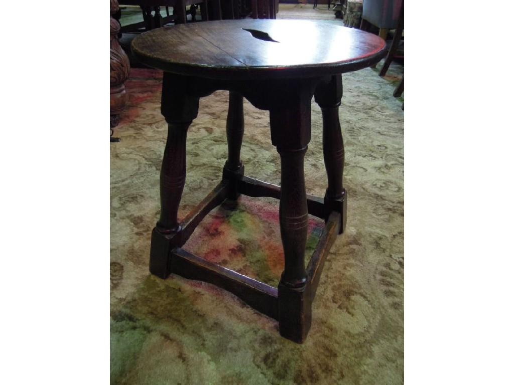 Appraisal: A reproduction oak stool with circular overhanging seat raised on