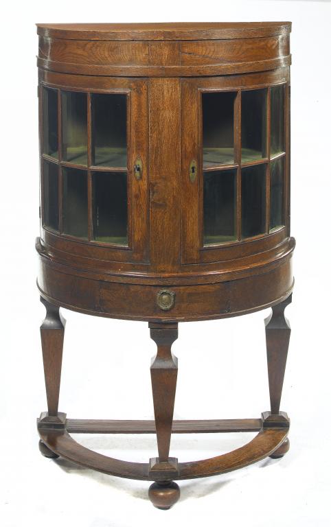 Appraisal: AN OAK SEMI CIRCULAR CABINET ON STAND in William and