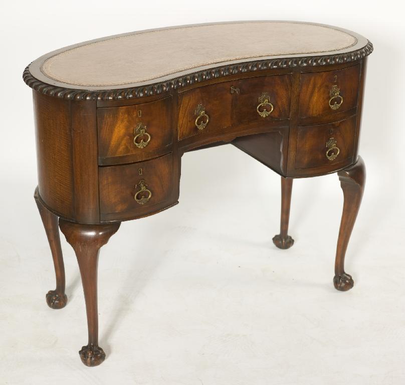 Appraisal: GEORGE III STYLE RENIFORM DESK the leather-inset top within a