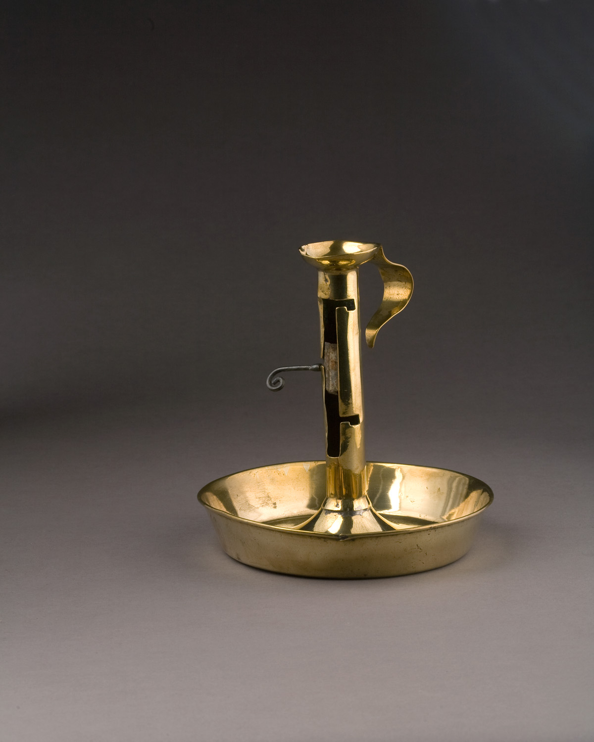 Appraisal: GEORGE I BRASS CANDLE SAVER CHAMBERSTICK CIRCA The cylindrical column