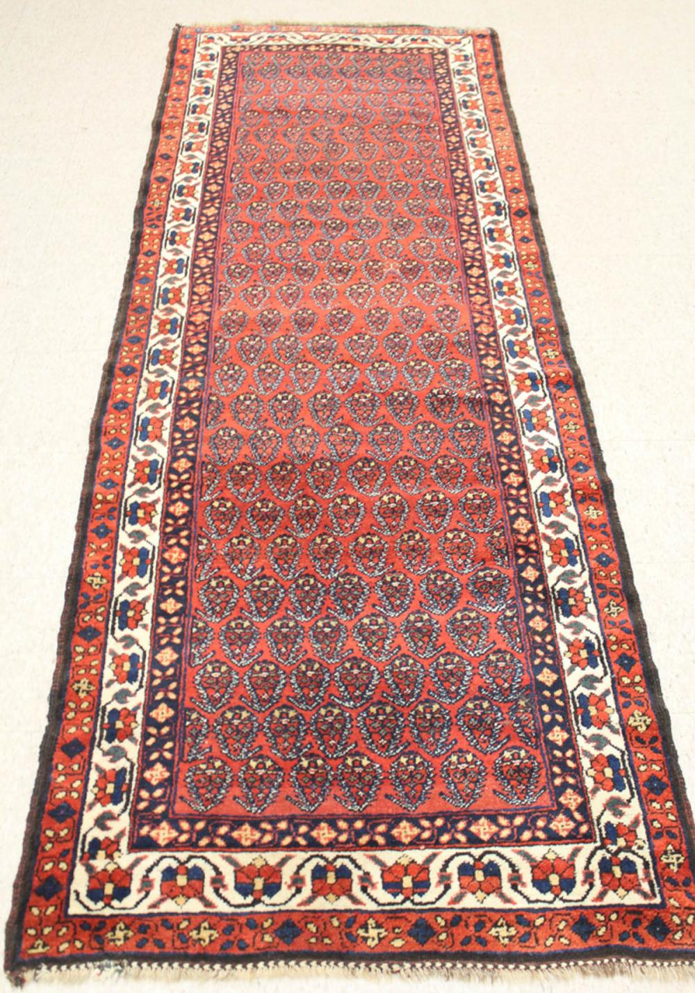 Appraisal: HAND KNOTTED PERSIAN TRIBAL HALL RUG repeating boteh motif on