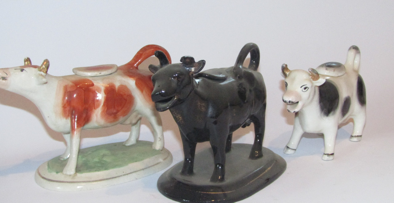 Appraisal: A thC Staffordshire cow creamer with tail handle and stopper