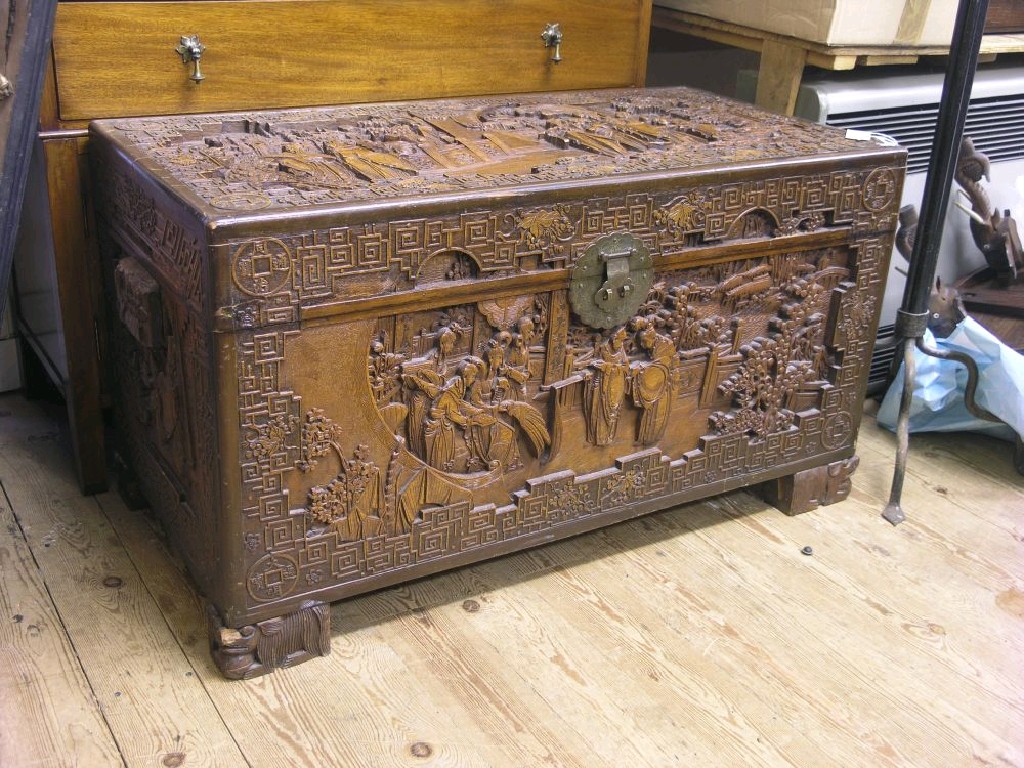 Appraisal: A Far Eastern camphorwood trunk deeply carved with figures at