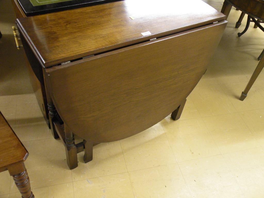 Appraisal: An oak oval drop leaf table on turned legs