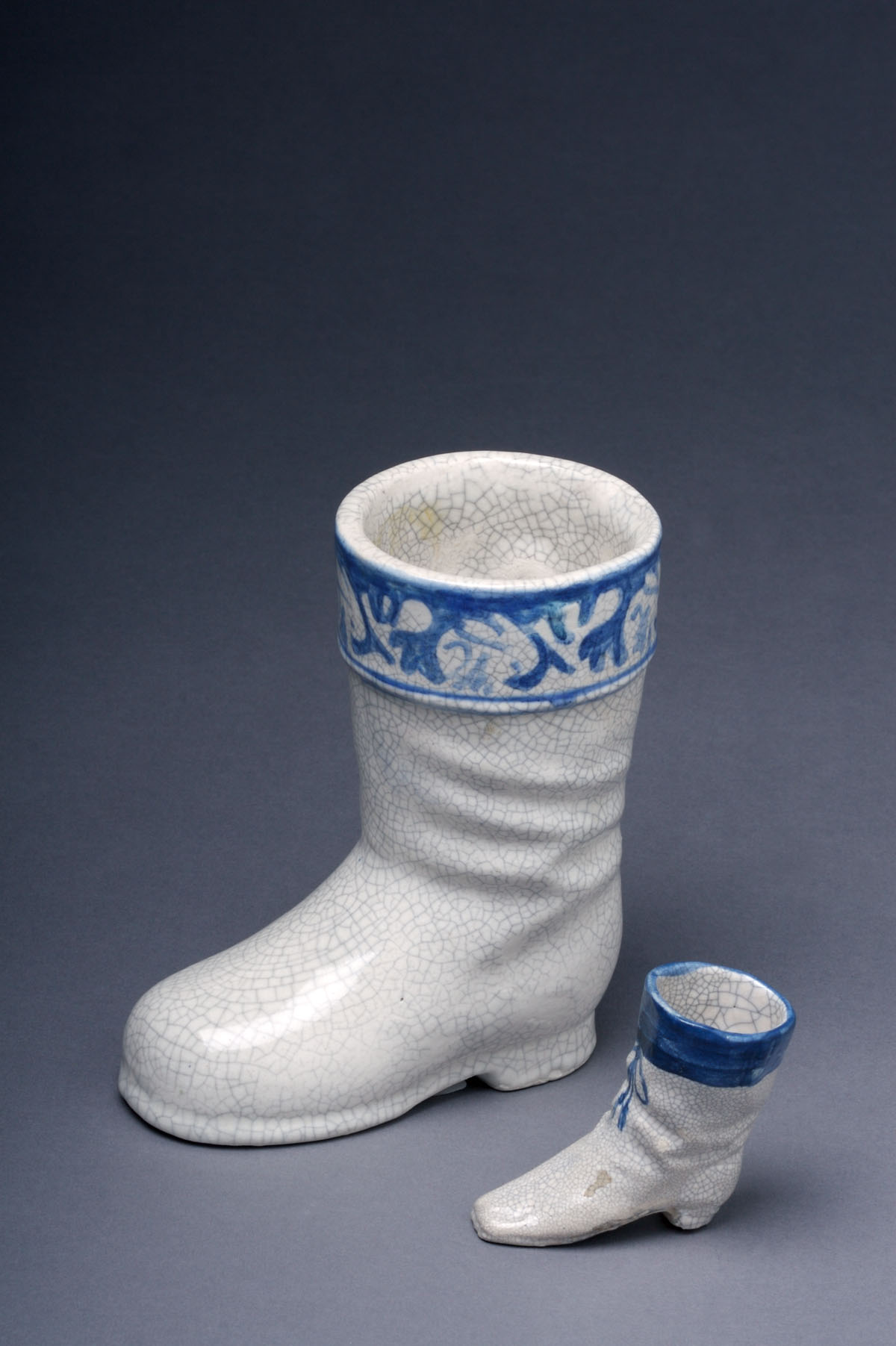 Appraisal: DEDHAM POTTERY MINIATURE BOOT Painted with a ribbon-tied wide blue