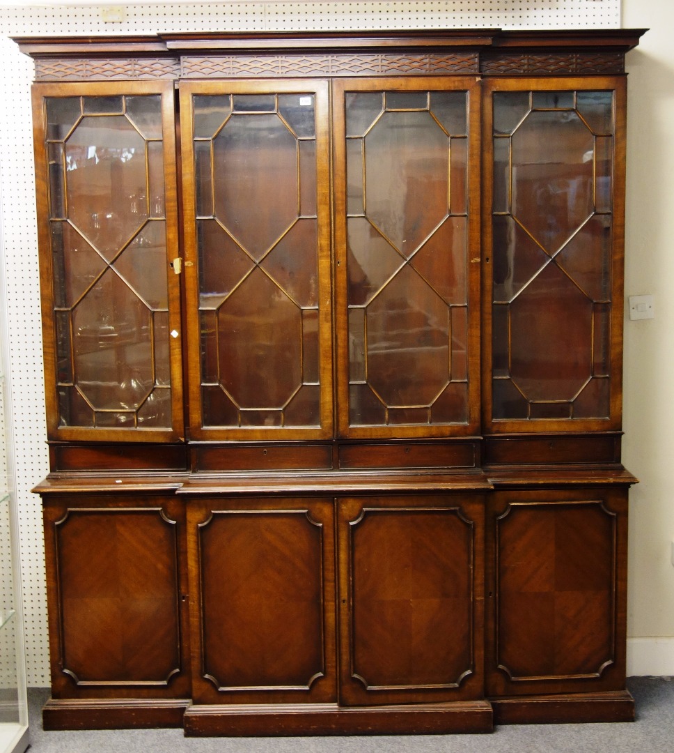 Appraisal: A George III style mahogany breakfront bookcase with four astragal