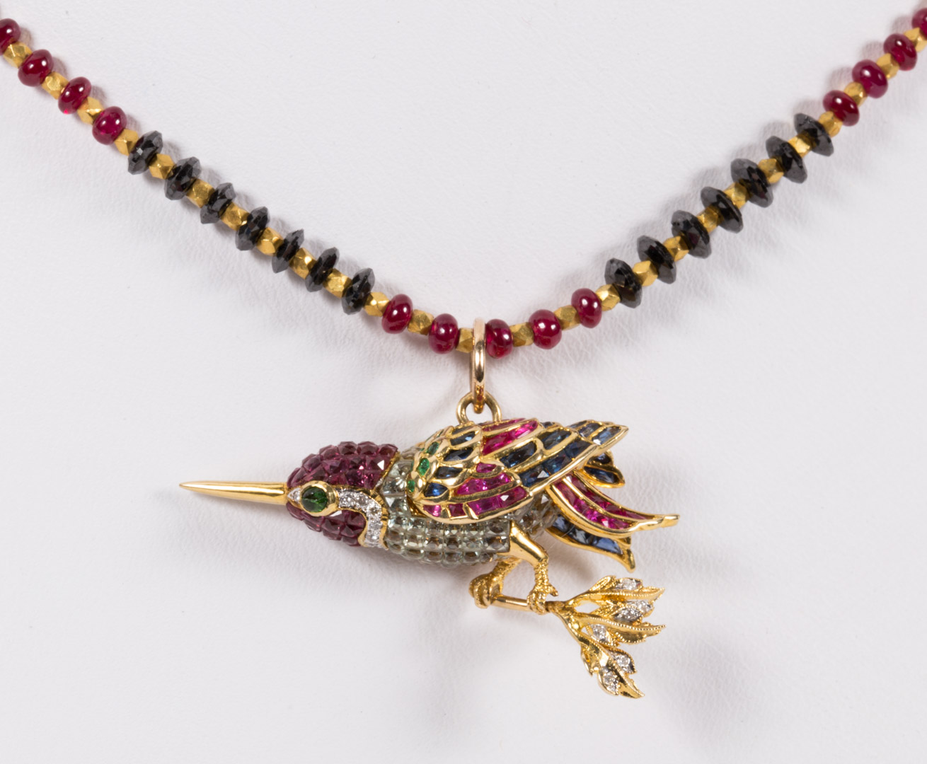 Appraisal: A Ruby Sapphire Hummingbird Necklace with two emeralds as the