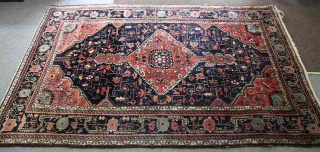 Appraisal: An Oriental rug with single madder medallion and spandrels on