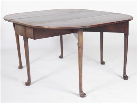 Appraisal: A George III oak drop leaf table the oval top