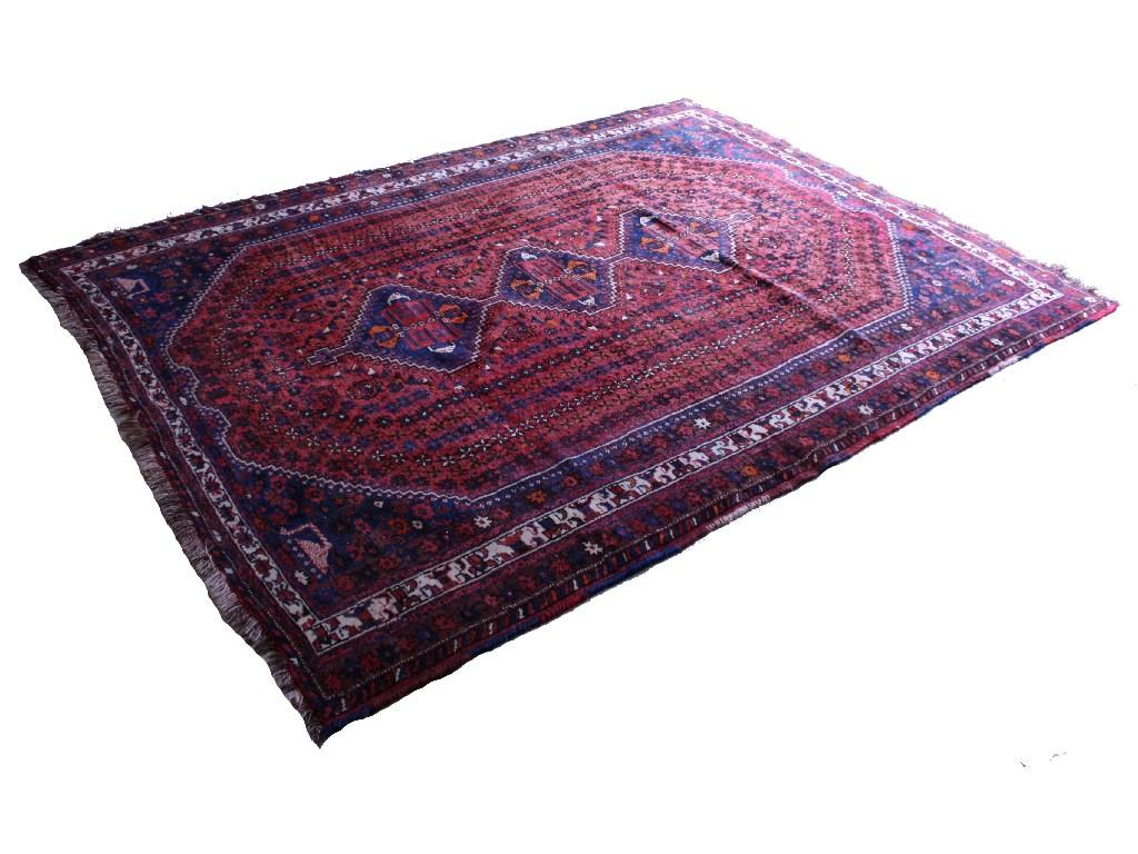 Appraisal: Persian style wool rug worked with three stylised guls on