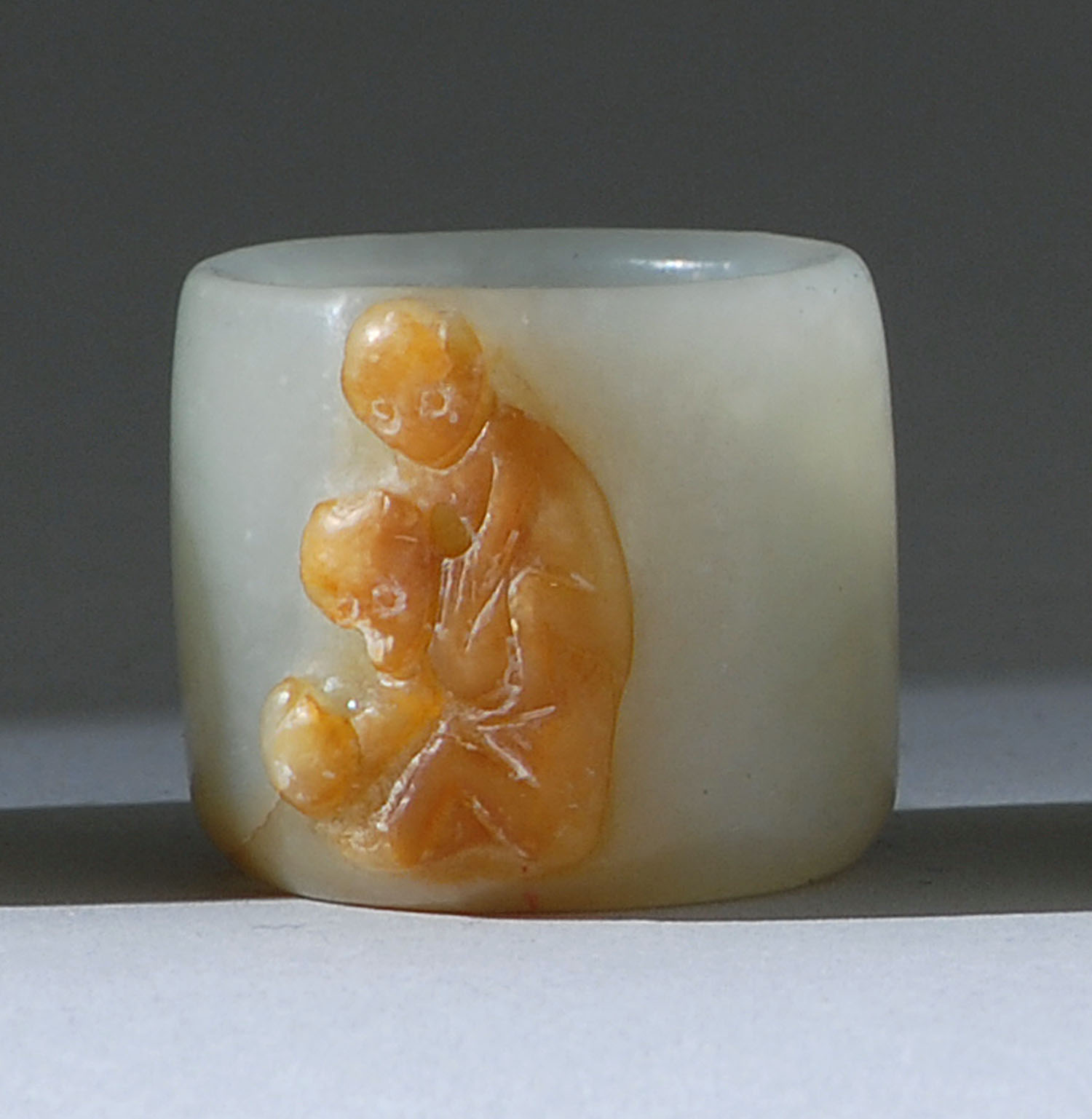 Appraisal: RUSSET AND WHITE JADE THUMB RING th CenturyWith relief carving