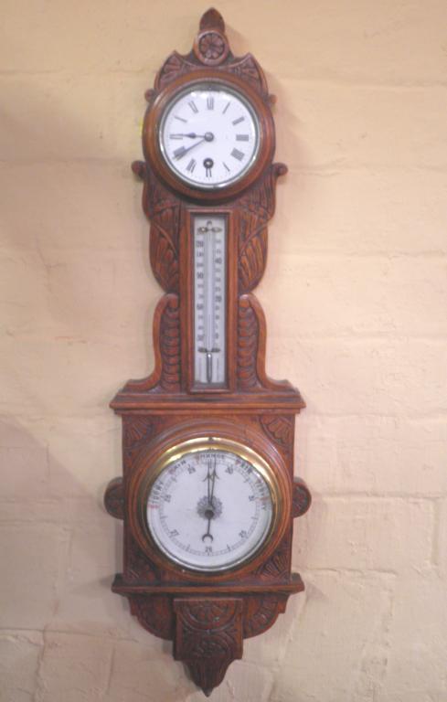 Appraisal: A late Victorian barometer and clock in a carved oak