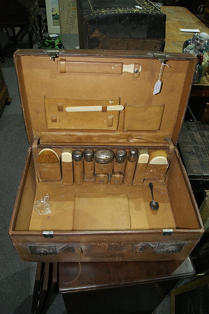 Appraisal: A LEATHER GENTLEMAN'S VANITY CASE with silver topped jars ivory