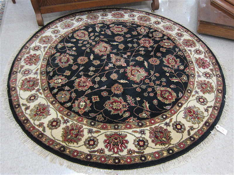 Appraisal: ROUND ORIENTAL ACCENT RUG Indo-Persian floral design on black ground