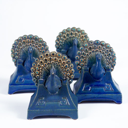 Appraisal: FULPER Four early peacock bookends with enameled tails covered in