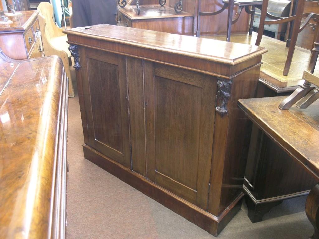 Appraisal: A Victorian mahogany side cupboard shallow form with carved corbels