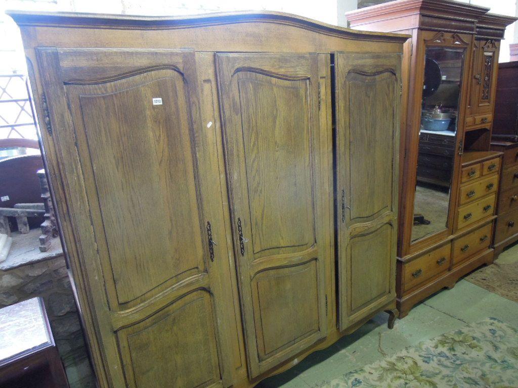 Appraisal: A continental oak dwarf wardrobe with arched and moulded cornice