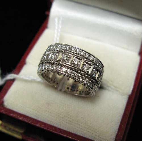 Appraisal: DIAMOND AND EIGHTEEN KARAT WHITE GOLD BAND the entire exterior