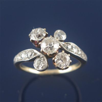 Appraisal: A Edwardian diamond cross over ring with three larger circular