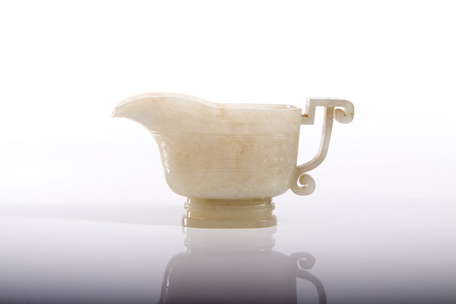 Appraisal: A CHINESE MUTTON FAT JADE LIBATION CUP in archaic bronze