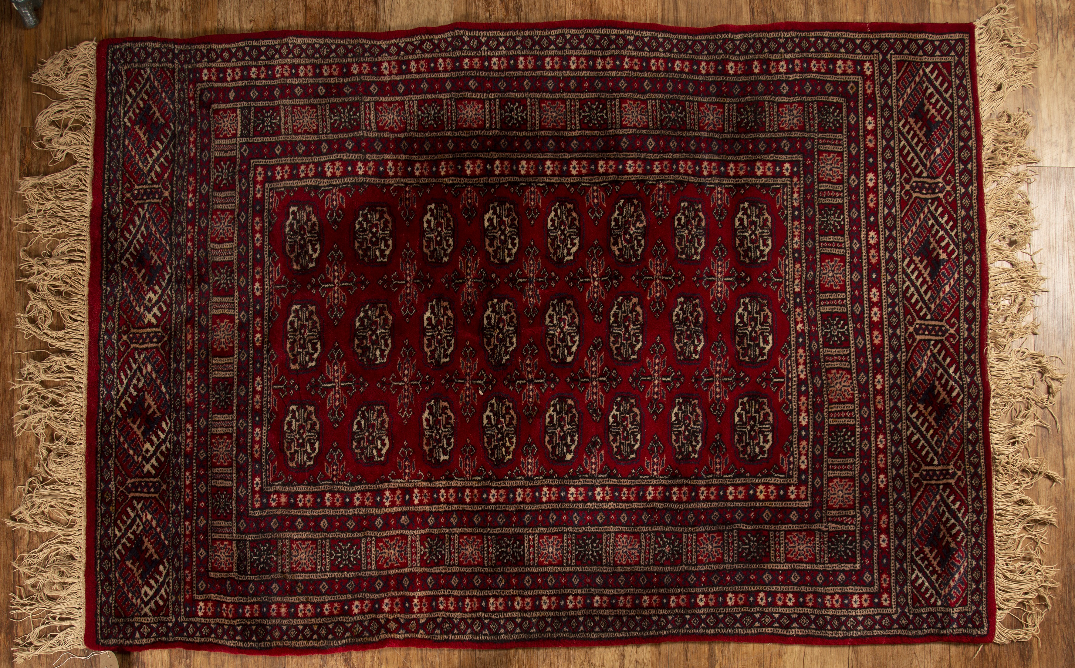 Appraisal: Red ground rugPakistan with a panel of elephant foot designs