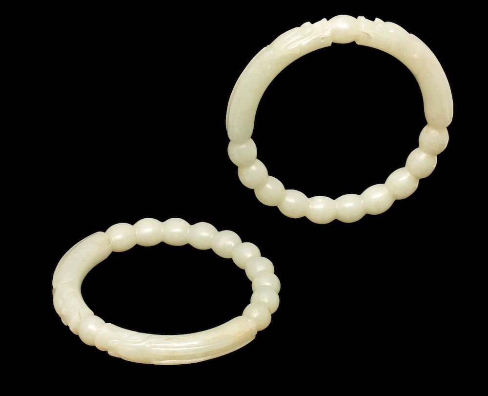 Appraisal: A PAIR OF CARVED JADE BRACELETS Carved jade bangle bracelets