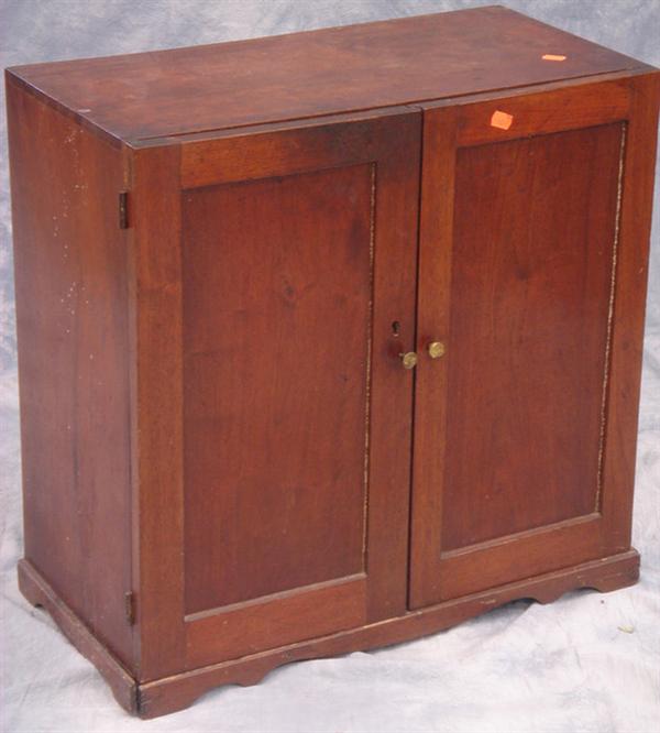 Appraisal: Walnut door counter top cupboard on a shallow bracket base