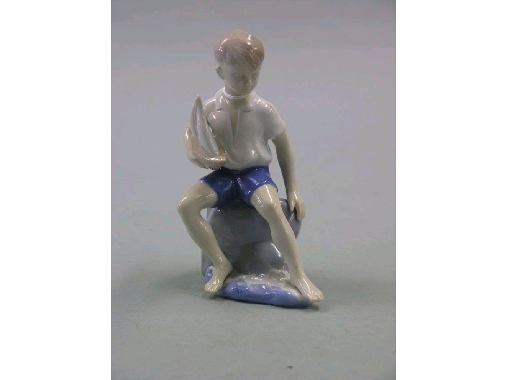 Appraisal: A Copenhagen-style porcelain model of a boy seated holding pond