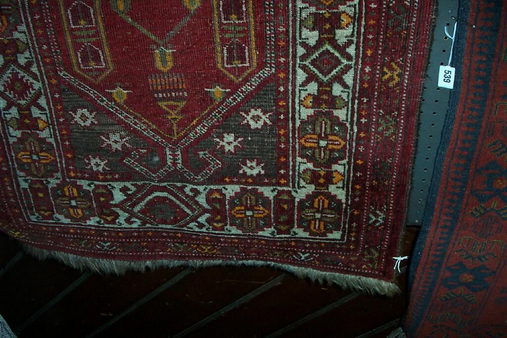 Appraisal: A small red ground Eastern wool prayer rug with geometric