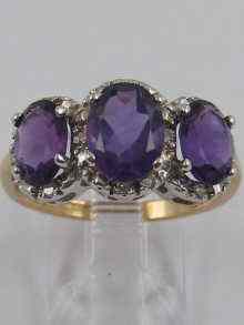 Appraisal: A hallmarked ct gold three stone amethyst and diamond ring